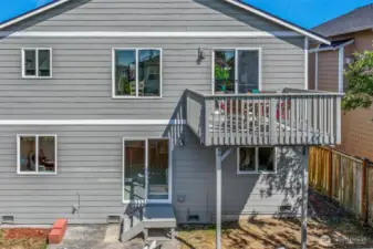 Rear elevation shows the easy connection between the upper deck and the daylight lower level. A second slider opens to the patio, creating two distinct outdoor zones for year-round enjoyment.