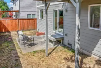 Another view of the patio and yard highlights low-upkeep spaces and side-yard access. The layout offers room for play, pets, or raised beds without heavy weekend maintenance.
