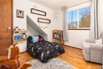 One of the bedrooms on the upper floor features hardwood floors.