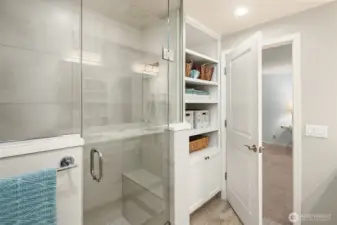 Stylishly updated en-suite bath with generous walk-in shower & built-in storage.