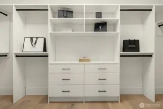 Natural light streams through the large skylight, highlighting the impressive size and design of the primary closet with custom organizers.