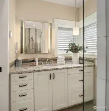 The main floor bedroom features an ensuite bath with custom painted cabinets, granite counters, radiant heated floor and Kohler bidet toilet seat.