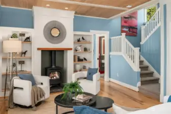 The richly detailed living room is warmed by a cozy gas fireplace operated on a thermostat.  Warm pine paneling embraces the ceiling and millwork trim wraps the stairway and built in shelving.