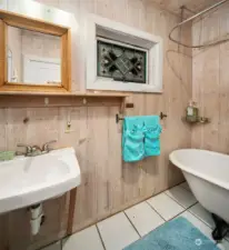 Main floor bath with tiled floor, clawfoot tub and shower.