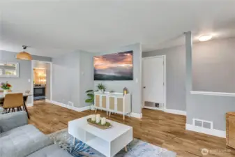 View of the living room facing the central hallway. Fresh paint and  stylish  vinyl plank flooring throughout.