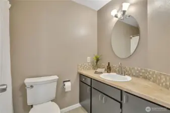 Main hall bathroom is centrally located in the home for easy access. The flooring is ceramic tile.