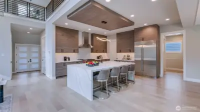 Enviable gourmet kitchen boasts 48" Subzero Refrigerator, Wolf Double-Oven, 6-Burners & Griddle Range, 48" Zephyr Pro Wall Hood, Sharp Microwave Drawer, and anchored by an oversized waterfall island.