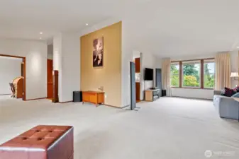 View from the living room showing the stunning entry wall, accent lighting, and views to the office and dining room. The beautiful windows bring in lots of natural light and show off the stunning landscape of this property.