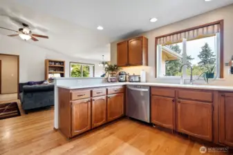 A view from the kitchen into the family room and breakfast nook area where the hardwoods continue with more of the gorgeous vaulted ceiling complete with a ceiling fan.