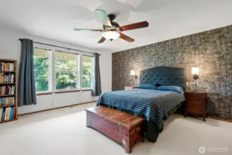 The spacious primary bedroom (bedroom 3 of 3) with view of the backyard.