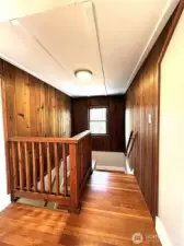 Stairwell leading to two upstairs bedrooms, featuring beautiful woodwork.