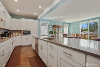 Gourmet kitchen with gas cooktop, double wall oven, french door refrigerator, stainless appliances, slab quartz countertops, center island eating bar that opens to the great room (living and dining rooms).