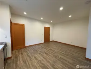 Lower 1 bedroom unit living area. Washer/druer in closet at end of counter. Front door to the right of frame.