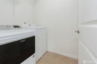 Laundry room with full closet for storage behind door.