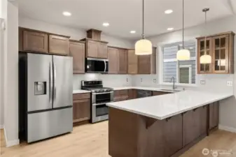 Kitchen features quartz countertops and full tile backsplash and extended eating bar. Cabinet color to be Toffee not pictured here.