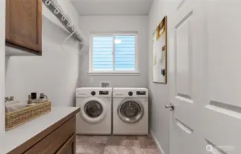 Separate laundry room with cabinets and a high hanging shelf for extended storage. Washer and Dryer will be included with this home. Virtually staged photo.