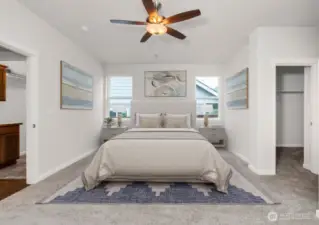 Virtually staged photo of primary bedroom featuring walk-in closet and 5-piece bath suite.