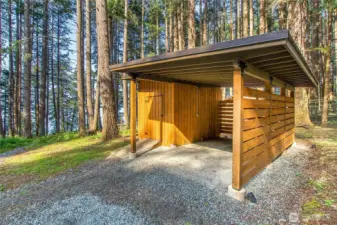 Carport with storage space is near the main cabin.