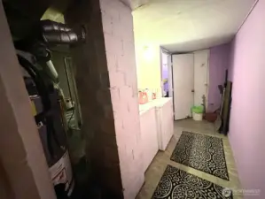 Laundry Room & Utilities - Downstairs.  End of Hall Bathroom on Left and Downstairs Exit Door (Center).