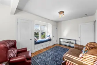 Main Floor Bedroom: A cozy retreat featuring a built-in window seat with storage drawers.