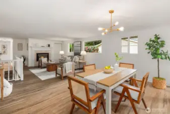The beautiful gas fireplace is framed by a classic mantel, adding warmth and charm. The open railing along the stairs enhances the sense of space, creating an airy and connected feel. Large windows fill the room with natural light, making it an ideal spot to relax and unwind.