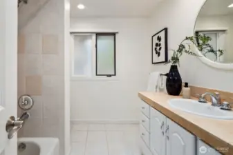Light colors and a window for natural light give this main bath an open and inviting feel.