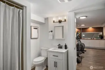 The basement features a walk-through three-quarter bath, with two doors for privacy, with new vanity, sink and toilet. Adjacent is a versatile room, ideal for a home gym, offering privacy and convenience for your fitness routine. Having a bathroom nearby adds to the practicality of this workout space, making it easier to freshen up post-exercise.