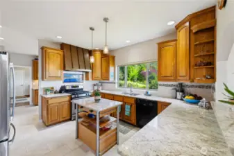 Updated kitchen with slab Granite and new flooring.  The doorway in the background leads the Garage.  The cabinets between the kitchen and garage door are in the Utility Room. Through the open doorway is the Office/Den.
