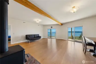 This is the lower-level Great Room.  Twin sliders open the lower-level deck and hot tub.  Lots of open space, a wood burning stove and a full kitchen/bar behind the stove. That's a second guest bedroom through the door on the lelft.