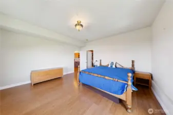 This is the lower-level Guest Bedroom with a large walk-in closet and a huge water view window.  You can see the kitchen just outside the open door.