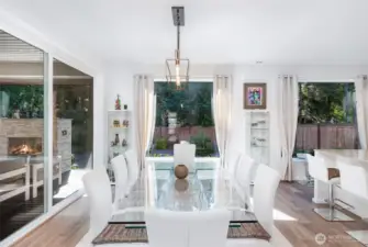 Dining area is bathed in natural light, surrounded by large windows from every direction—offering serene views and a bright, airy atmosphere.
