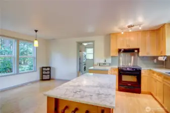 Dining adjoins the kitchen with a large window overlooking the outdoor space.