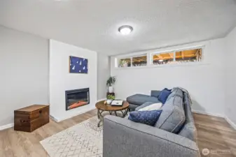 Sleek LED fireplace framed by brick completes the space.