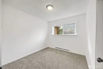 Lower-level bedroom ideal for multigenerational living or a home office, conveniently near the bathroom.