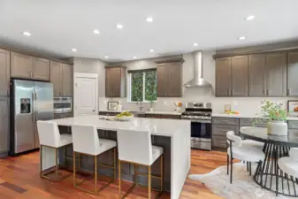 Fully remodeled designer kitchen with waterfall quartz island, seamless quartz backsplash, farmhouse sink, gas range, and stainless steel appliances—ideal for entertaining and everyday living.