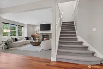 Refinished Brazilian cherry hardwood flooring leads toward the open stairwell and great room, highlighting the home’s flow and cohesive design.