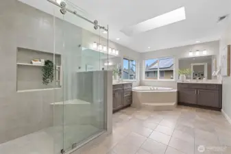 Custom glass shower with nooks and seat.