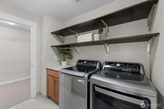 Convenient upstairs laundry room with dual access from both the primary suite and hallway, designed for everyday functionality and ease.