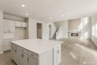 Open-concept kitchen-to-great-room view featuring the center island with white quartz countertop, abundant cabinetry, and tons of natural light. Photos are representative only and may display different color package and/or upgrades.