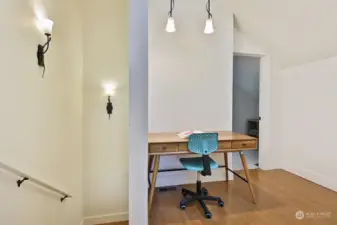 We are now upstairs. This is the flex room on the landing at the top of the stairs. Your back is to BR Suite #2 and the doorway ahead leads to the Primary Suite.