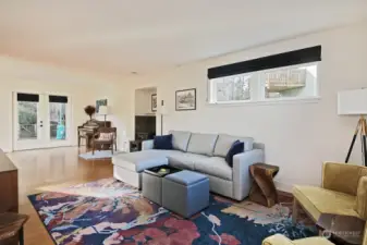 Your back is to the front door. The dining area and kitchen are around the corner to your left. The French doors lead to your back deck. Note the freestanding propane fireplace/stove just beyond the sofa.