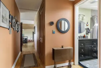 Full bath at right, then looking down the hall toward the living, dining, kitchen portion of the house.
