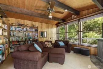 Old world style family room at the back of the house has rock fireplace