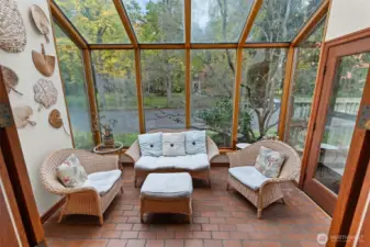 This cozy sunroom invites you to curl up with a book and take in the peaceful scenery.