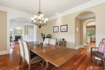 The formal dining room on the right features an arched entrance into the Butler’s pantry with wine fridge and glass upper cabinets.