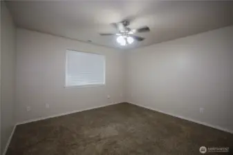 Large primary bedroom, with large window for sunlight.