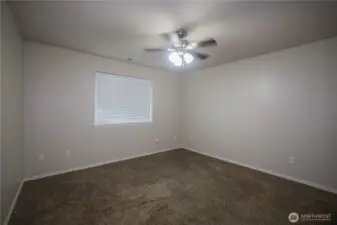 Large primary bedroom, with large window for sunlight.
