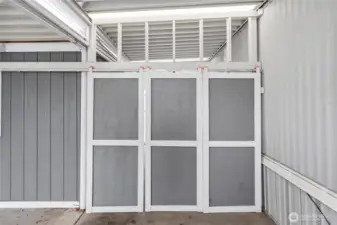 Barn doors off the carport open to a sunroom and storage/workshop.