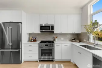 Stainless steel appliance package and modern tile backsplash elevate this culinary space with a polished contemporary edge.