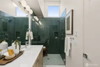 Luxe primary bath featuring rich tilework, dual vanities, and contemporary fixtures for a refined experience.